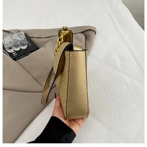 Vue détaillée du sac à épaule élégant en or métallisé avec chaîne dorée chic.