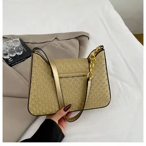 Élégant sac à bandoulière tissé doré avec belle chaîne métallique pour un style chic.