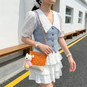 Chic orange rhinestone bucket bag with cute knit bear pendant, stylish crossbody shoulder bag.