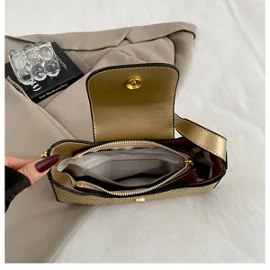Vue détaillée de la doublure intérieure du sac à épaule doré avec poche zippée et fentes.