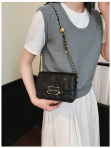 Details of black quilted chain shoulder bag, stylish luxury style small square bag view.