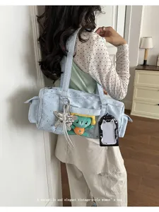Detail view of light blue star itabag with clear pocket and cute bear charm pendant.