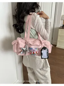 Detailed view of the cute pink ita bag with star patterns, clear window and charm pendants.