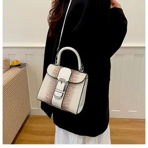 Gedetailleerd overzicht van vintage slangenprint handtas met handvat en metalen gesp.