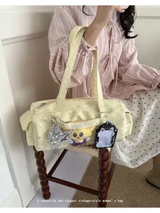 Canvas shoulder bag detail showing star print fabric, front transparent pocket and cute plush charm.