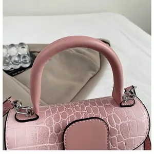Pink retro crocodile texture handbag handle detail closeup elegant shoulder crossbody bag.