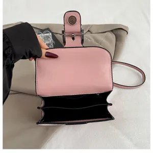 Pink leather handbag interior detail showing compartments and magnetic snap closure design.
