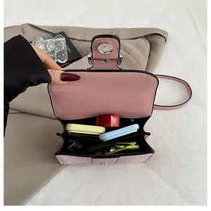 Detailed view of pink leather shoulder bag interior with multi compartments and fine texture.