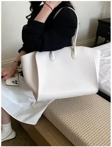Detail view of the large white leather tote bag, showing minimalist design and texture.