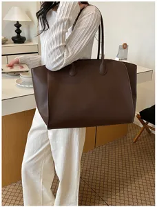 Detail shot of a large brown leather tote bag showcasing its spacious interior and classic style.