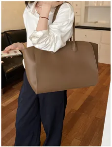 Detailed shot of a large brown leather tote bag showcasing its spacious commute design.