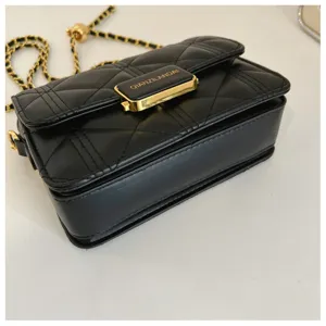 Detailed view of black quilted chain shoulder bag, classic flap design with gold hardware.