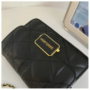 Detailed close-up of a black quilted chain shoulder bag with elegant gold hardware.