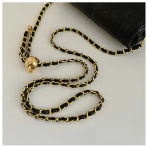 Quilted leather shoulder bag detail with luxury gold chain strap and metal adjustment ball.