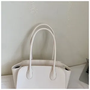 Close-up detail of the elegant beige tote bag, showing premium texture and sturdy double handles.