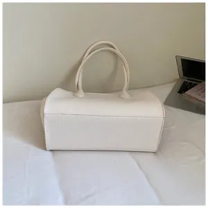 Detailed view of the elegant beige leather tote bag with sturdy handles, perfect for daily wear.