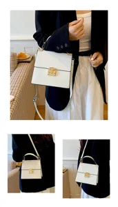 Detailansicht einer eleganten weißen Schultertasche mit goldfarbenen Beschlägen.