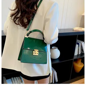 Glänzende grüne Damentasche mit Schulterriemen, elegante Umhängetasche mit Metallverschluss.