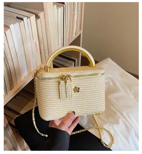 Nahaufnahme der geflochtenen Vintage-Box-Tasche mit Metallgriff und schickem Blumen-Akzent.