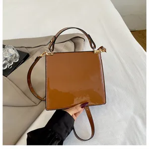 Braune Lackleder Handtasche, stilvolle Detailansicht mit praktischem Griff und Gurt.