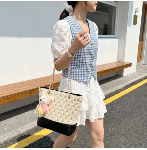 Dettaglio ravvicinato della borsa a spalla trapuntata vintage con decorazioni in strass.