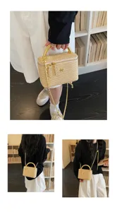 Detailansicht der gewebten Stroh-Kosmetiktasche mit Goldkette und stabilem Metallgriff.
