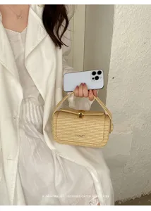 Vista dettagliata della borsa intrecciata in paglia con elegante chiusura metallica dorata.