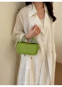 Dettaglio borsa a mano verde intrecciata con superficie testurizzata e raffinata chiusura dorata.