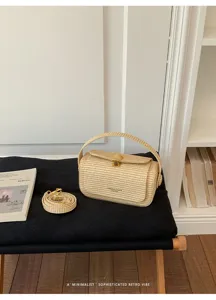Vista dettagliata della borsa di paglia intrecciata, elegante chiusura in metallo.