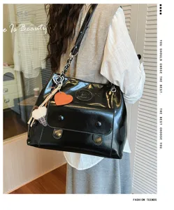Elegant black patent leather shoulder bag with metal chain strap and cute charms for daily use.