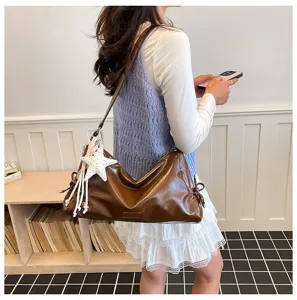 Detail view of the vintage brown slouchy shoulder bag with star charm and large capacity.