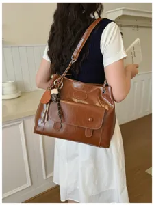 Retro brown leather shoulder bag with chain strap and front pocket, stylish commuter tote.