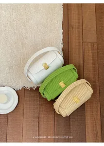Dettaglio della borsa a tracolla da donna intrecciata con elegante chiusura dorata.