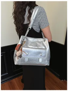 Silver vintage shoulder bag with chain strap and front pocket, stylish commuter tote bag.