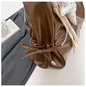 Brown leather tote bag detail with drawstring bow and cute star pendant charm stylish.