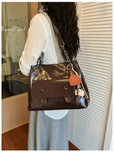 Vintage brown shoulder bag detail, large capacity tote with chain strap and cute charms.