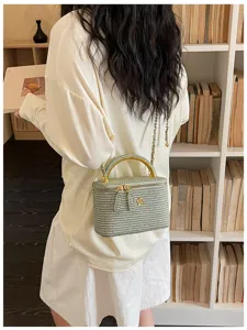 Detailansicht einer eleganten gewebten Vintage Kosmetiktasche mit Henkel und Kette.