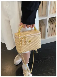 Detailansicht einer vintage gewebten Stroh Box Handtasche mit Metallgriff und goldener Kette.