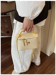 Detailansicht der gewebten Vintage Kosmetiktasche mit Griff, Goldkette und Blumendetail.
