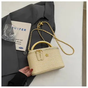 Detailansicht der eleganten geflochtenen Stroh-Kosmetiktasche mit Goldbeschlag und Kamelie.