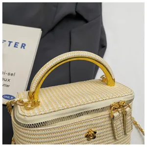 Detailaufnahme einer gewebten Kosmetiktasche mit Goldmetallgriff, Reißverschluss und eleganter Kette.