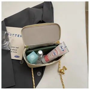 Detailaufnahme des gesteppten Ketten-Boxtaschen-Innenraums, elegante Kosmetik-Requisite.