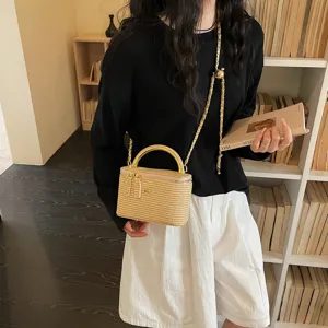 Borsa a mano chic in paglia intrecciata con manico dorato e tracolla a catena.