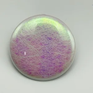 Close-up detail of circular holographic silk glitter badge film with iridescent color effect.