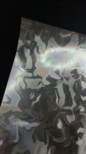 Close-up detail of holographic water ripple craft paper texture showing shiny silver reflections.