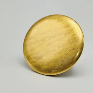 Gold metal badge backing detail view, elegant water wave texture for custom button pins.