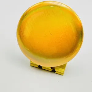 Closeup of holographic badge base paper, shiny gold circular design for anime merch DIY.