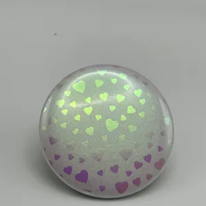 Holographic heart pattern badge detail shot, glossy circular cover accessory for collection.