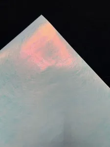 Special paper detail showing iridescent silk texture for badge packaging, glossy finish craft paper.