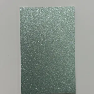 Detailed view of iridescent green glitter cardstock paper sheet for badge backing craft DIY.